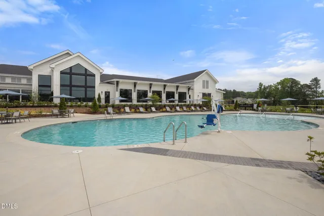 a view of a white house with a swimming pool and a yard
