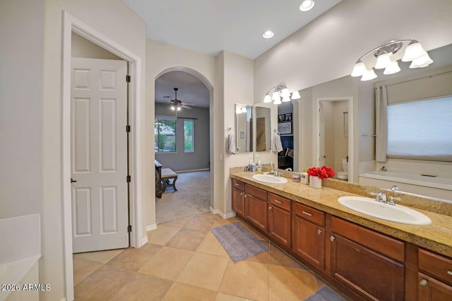 3978 East Hashknife Road Phoenix, AZ 85050 - Photo 15 of 29 a large bathroom with a large mirror vanity and sink