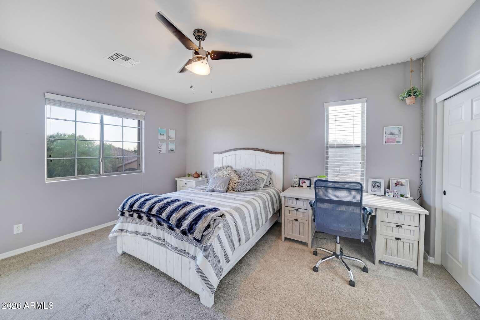3978 East Hashknife Road Phoenix, AZ 85050 - Photo 18 of 29 a spacious bedroom with a bed a chandelier and a window
