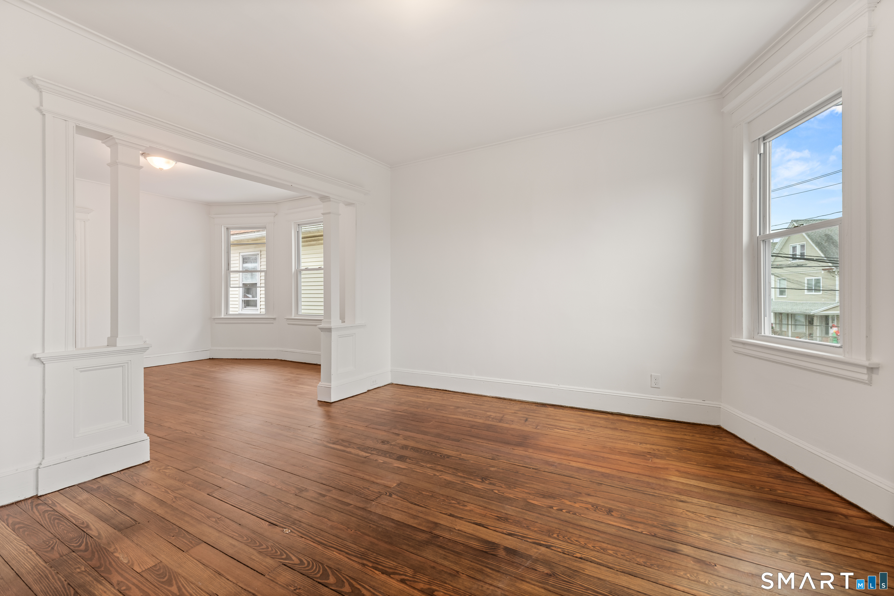 386 Huntington Road Bridgeport, CT 06608 - Photo 13 of 33 an empty room with wooden floor and windows