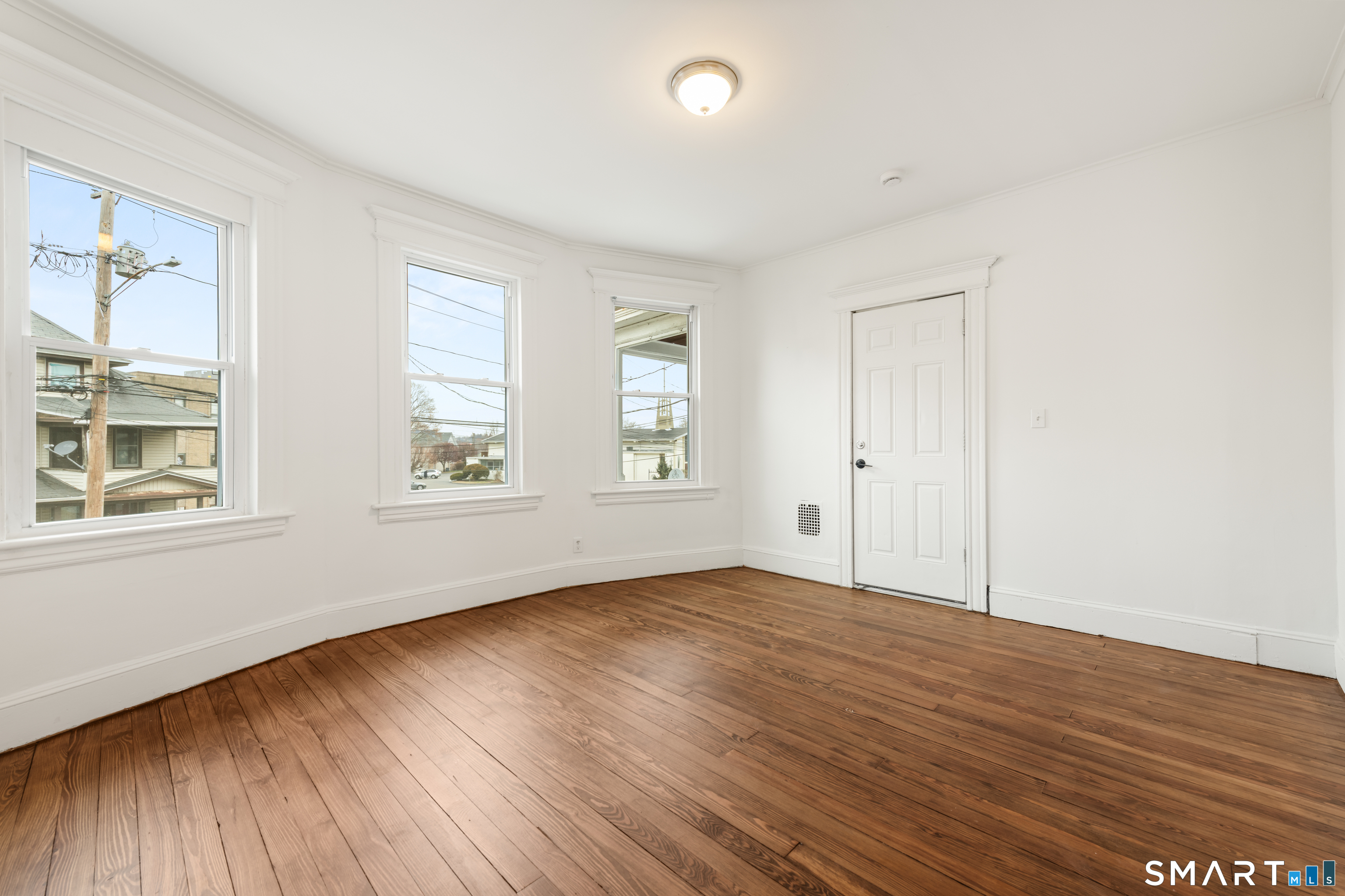 386 Huntington Road Bridgeport, CT 06608 - Photo 14 of 33 an empty room with wooden floor and windows