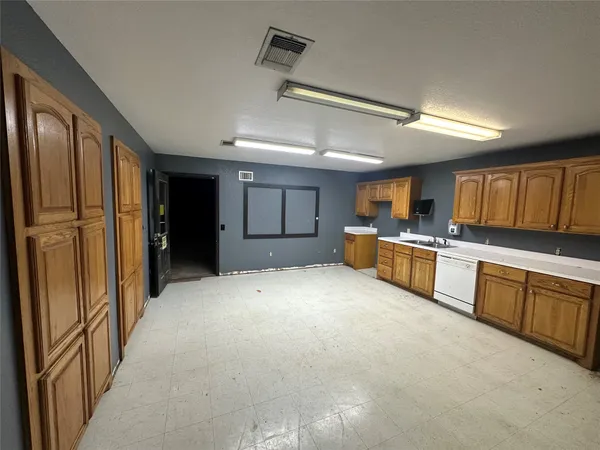 a large kitchen with cabinets and stainless steel appliances