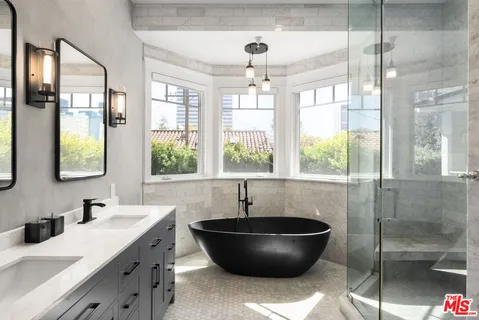 a living room with a large window and chandelier