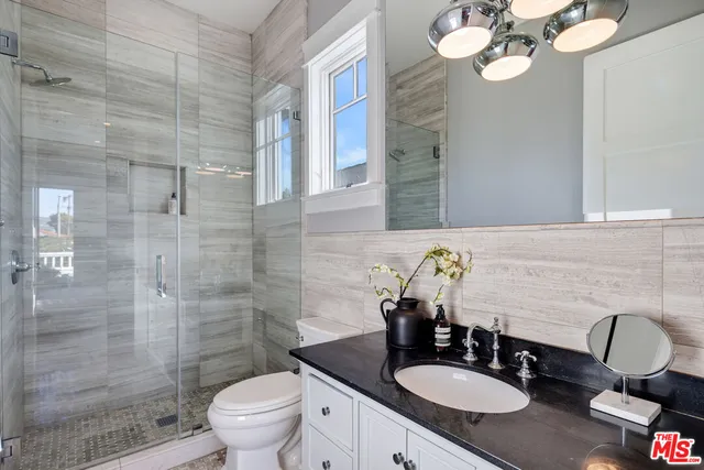 a bathroom with a granite countertop toilet sink and mirror