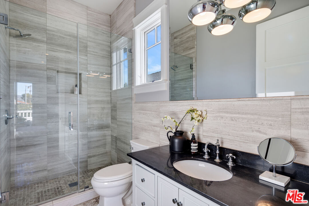 6336 Lindenhurst Avenue Los Angeles, CA 90048 - Photo 22 of 26 a bathroom with a granite countertop toilet sink and mirror