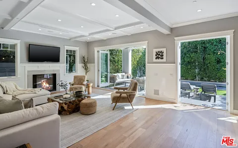 a living room with furniture fireplace and a large window