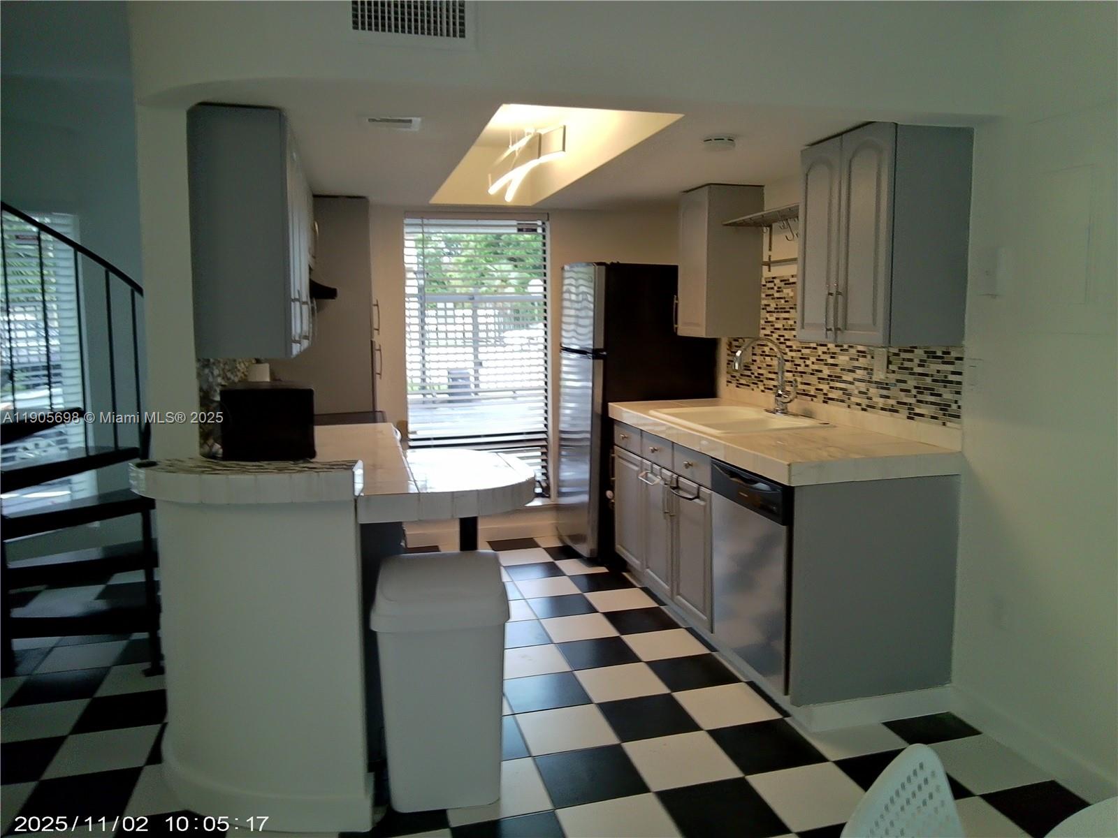 3036 Southwest 27th Avenue, Unit 5 Miami, FL 33133 - Photo 2 of 23 a kitchen with a sink and a stove top oven
