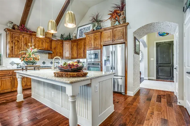 a kitchen with stainless steel appliances granite countertop a sink stove and cabinets