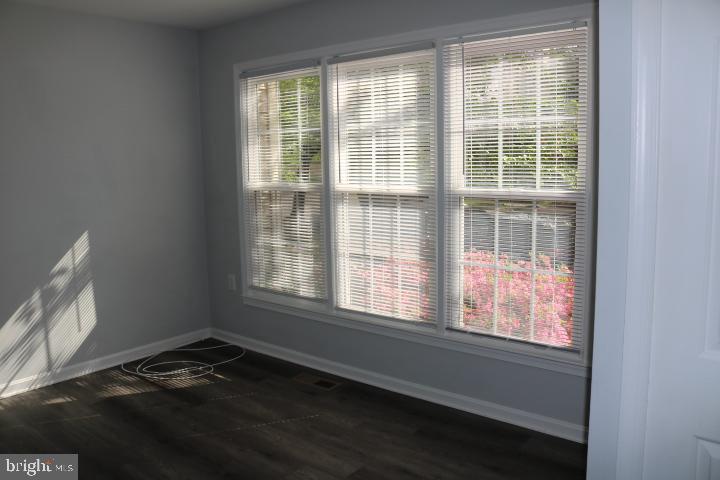 7313 Stream Way Springfield, VA 22152 - Photo 14 of 28 a view of an empty room with wooden floor and a window