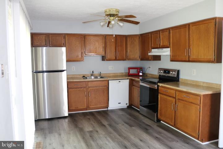 7313 Stream Way Springfield, VA 22152 - Photo 4 of 28 a kitchen with a refrigerator a stove a sink and cabinets