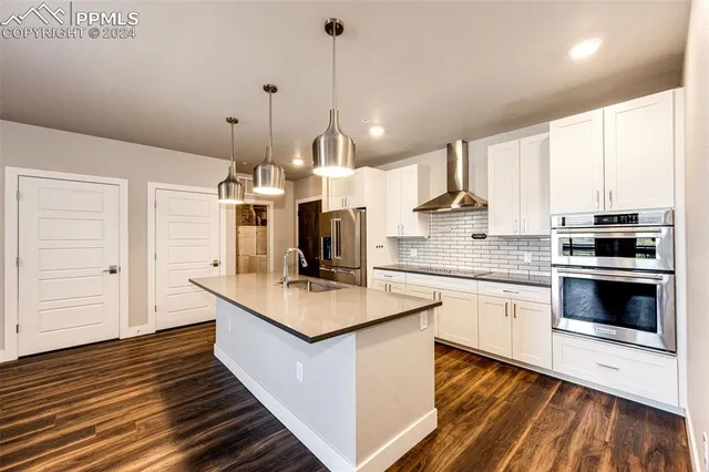 a large kitchen with stainless steel appliances kitchen island a large counter top