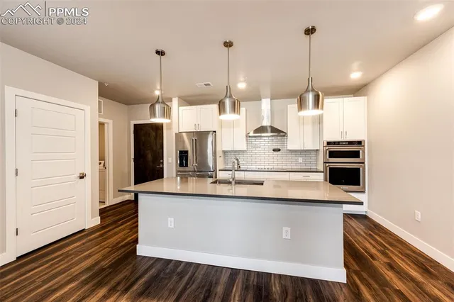 a kitchen with a sink and wooden floor