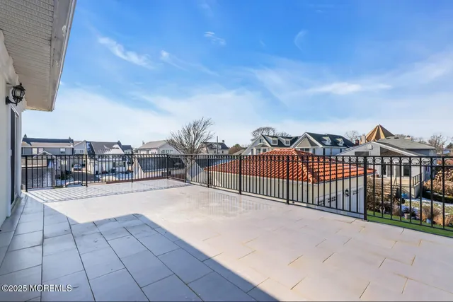a view of a house with a barbeque and wooden stairs