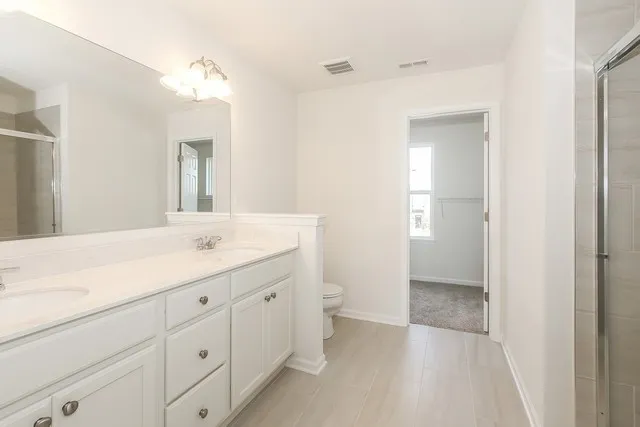 a bathroom with a toilet a sink a mirror and vanity