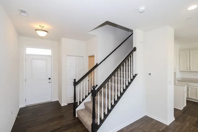 a view of a hallway with wooden floor and staircase