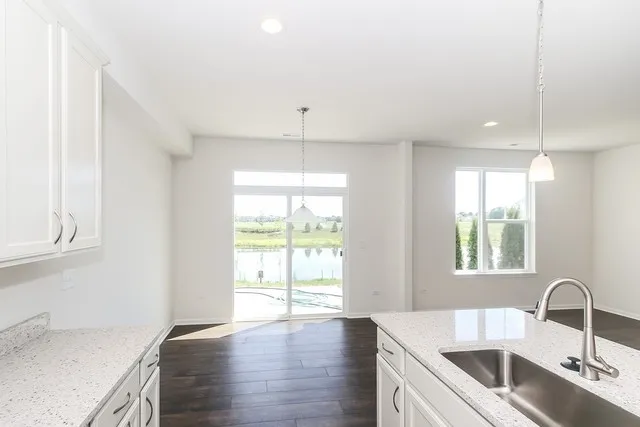 a kitchen with stainless steel appliances granite countertop a sink a stove and a wooden floors