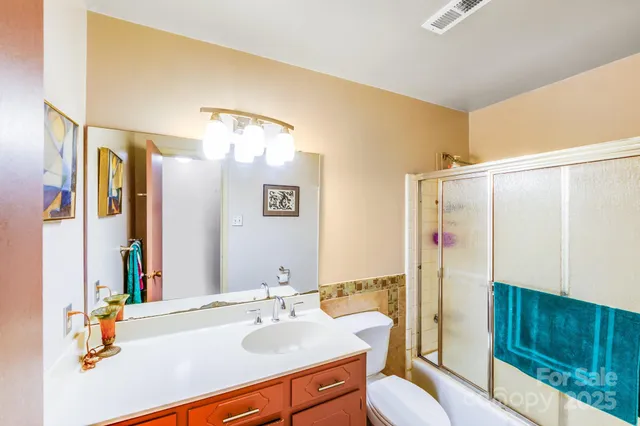 a bathroom with a sink vanity mirror and toilet