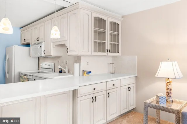 a kitchen with white cabinets and white appliances