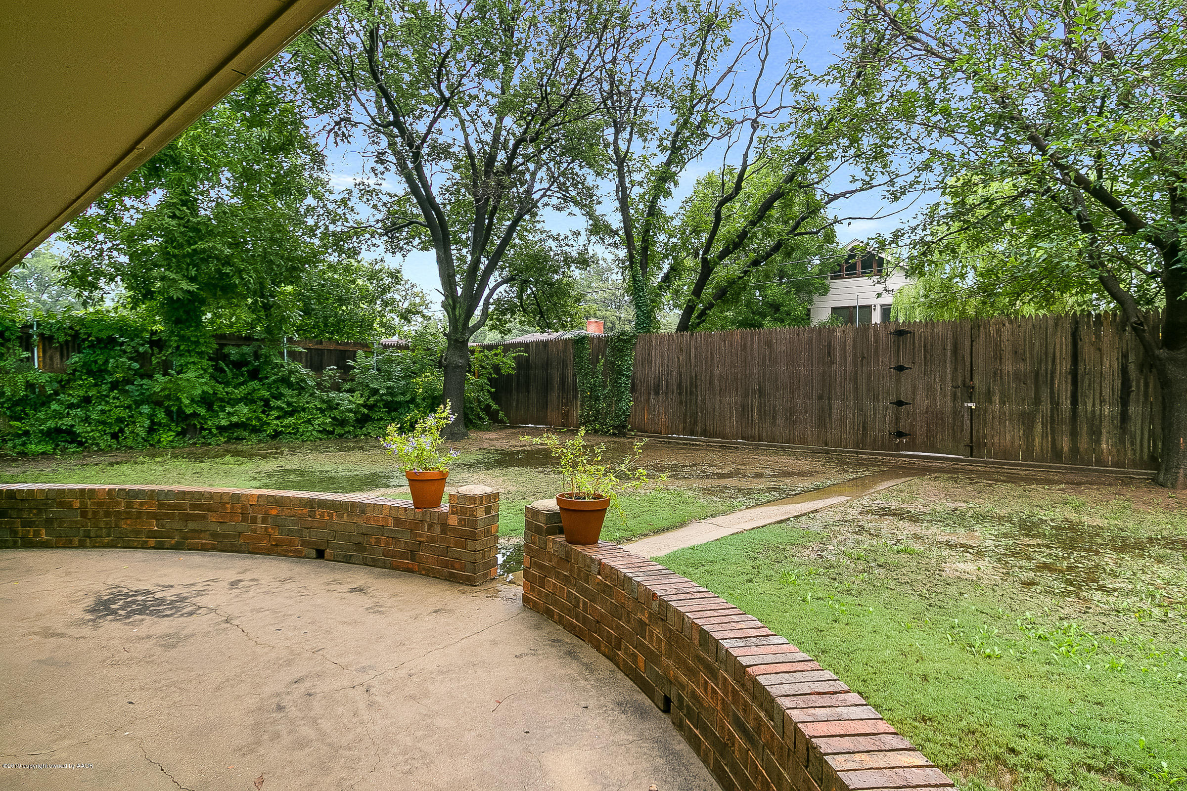 6309 Calumet Road Amarillo, TX 79106 - Photo 22 of 22 a view of a backyard with large trees and wooden fence
