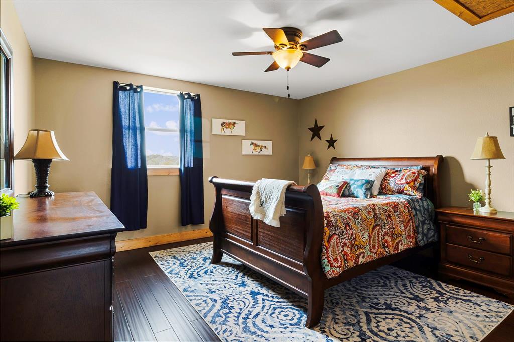 3200 Tx-75 Buffalo, TX 75831 - Photo 20 of 40 a bedroom with a bed and a table with potted plant on the wooden floor
