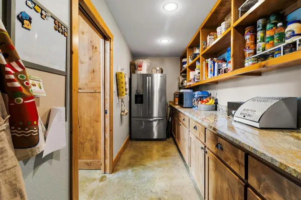 a kitchen with stainless steel appliances granite countertop a refrigerator a stove and a sink