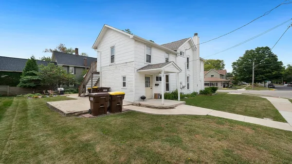 a view of a house with backyard and sitting area