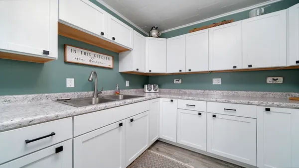a kitchen with granite countertop white cabinets and sink
