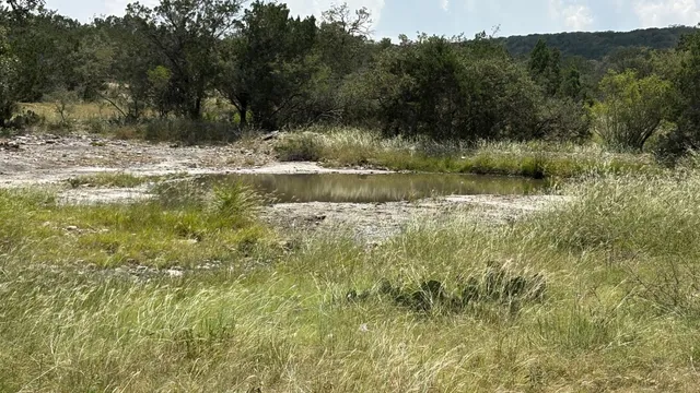 a view of a lake with lawn chairs