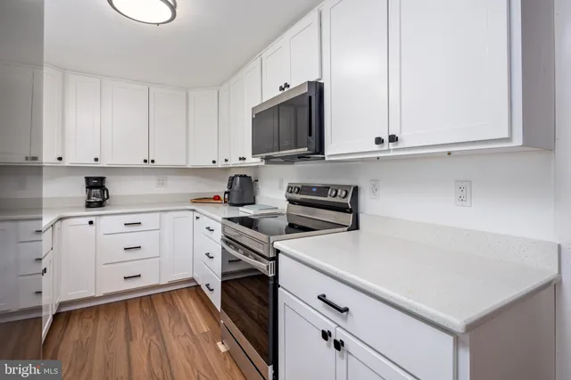 a kitchen with white cabinets and white appliances