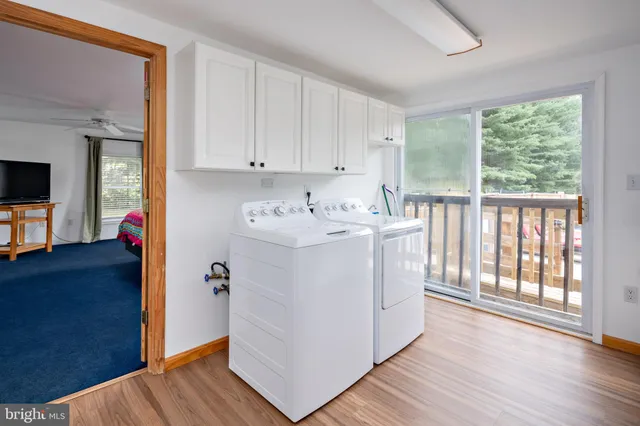 a utility room with wooden floor washer and dryer