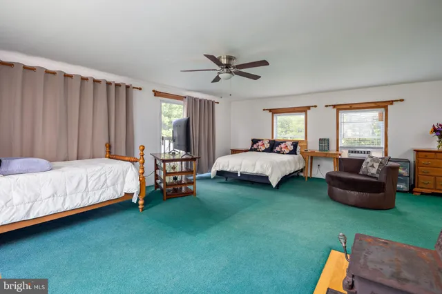 a bedroom with a bed couch and a window