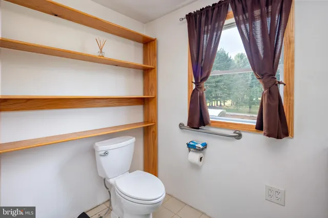 a bathroom with a toilet a sink and a window