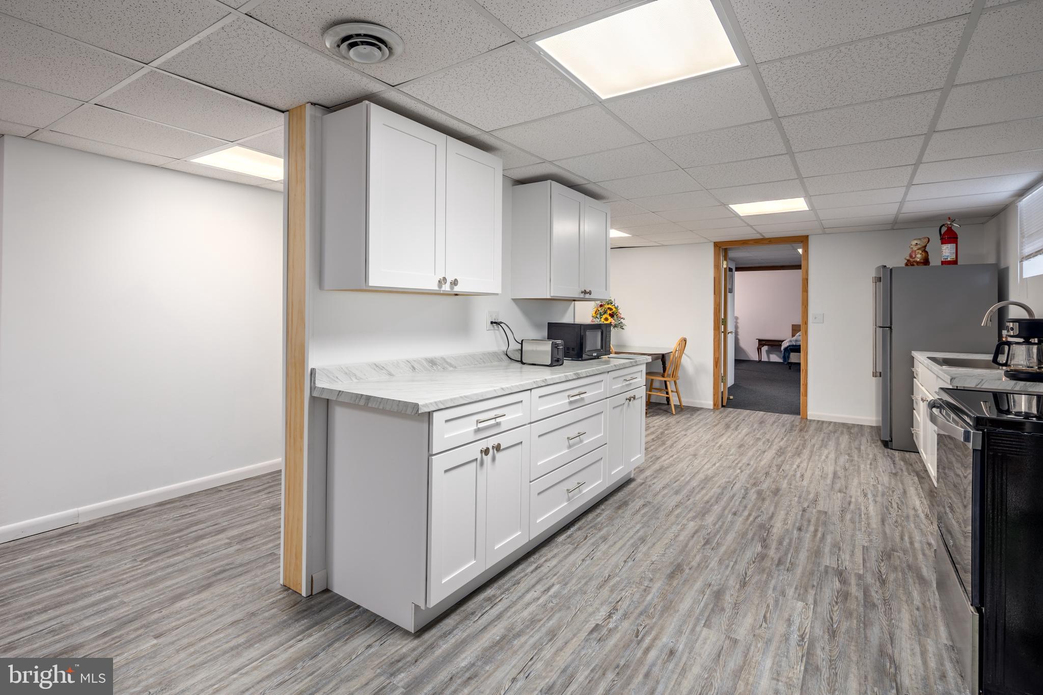 1045 Doyle Road Street, MD 21154 - Photo 26 of 47 a kitchen with granite countertop a refrigerator and a stove top oven