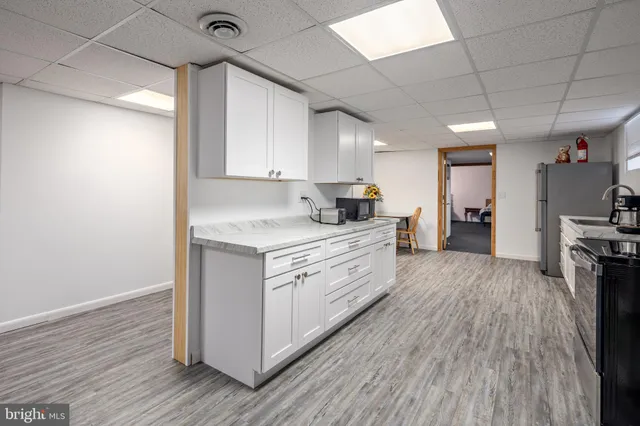 a kitchen with granite countertop a refrigerator and a stove top oven