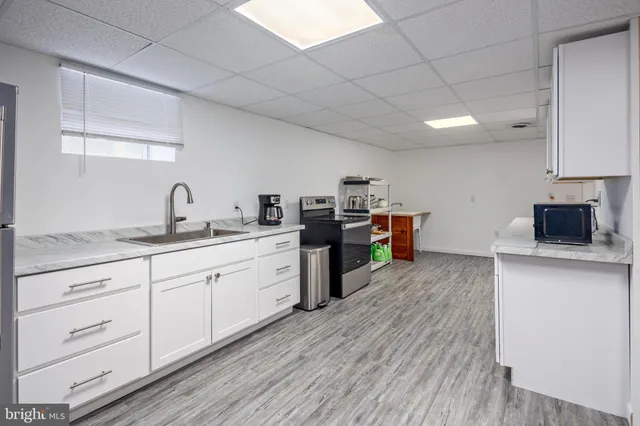 a kitchen with stainless steel appliances granite countertop a sink and cabinets with wooden floor