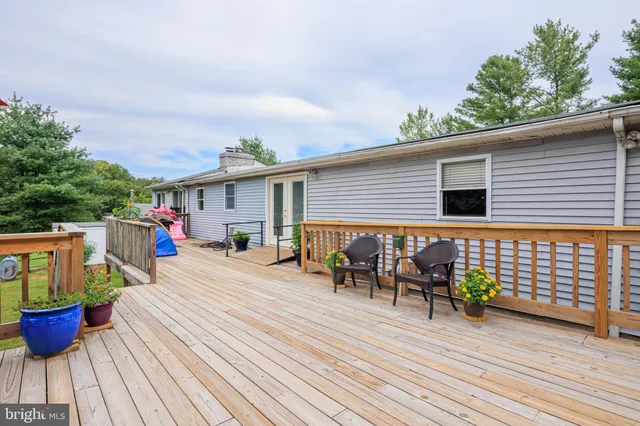 a view of a roof deck with table and chairs and wooden floor