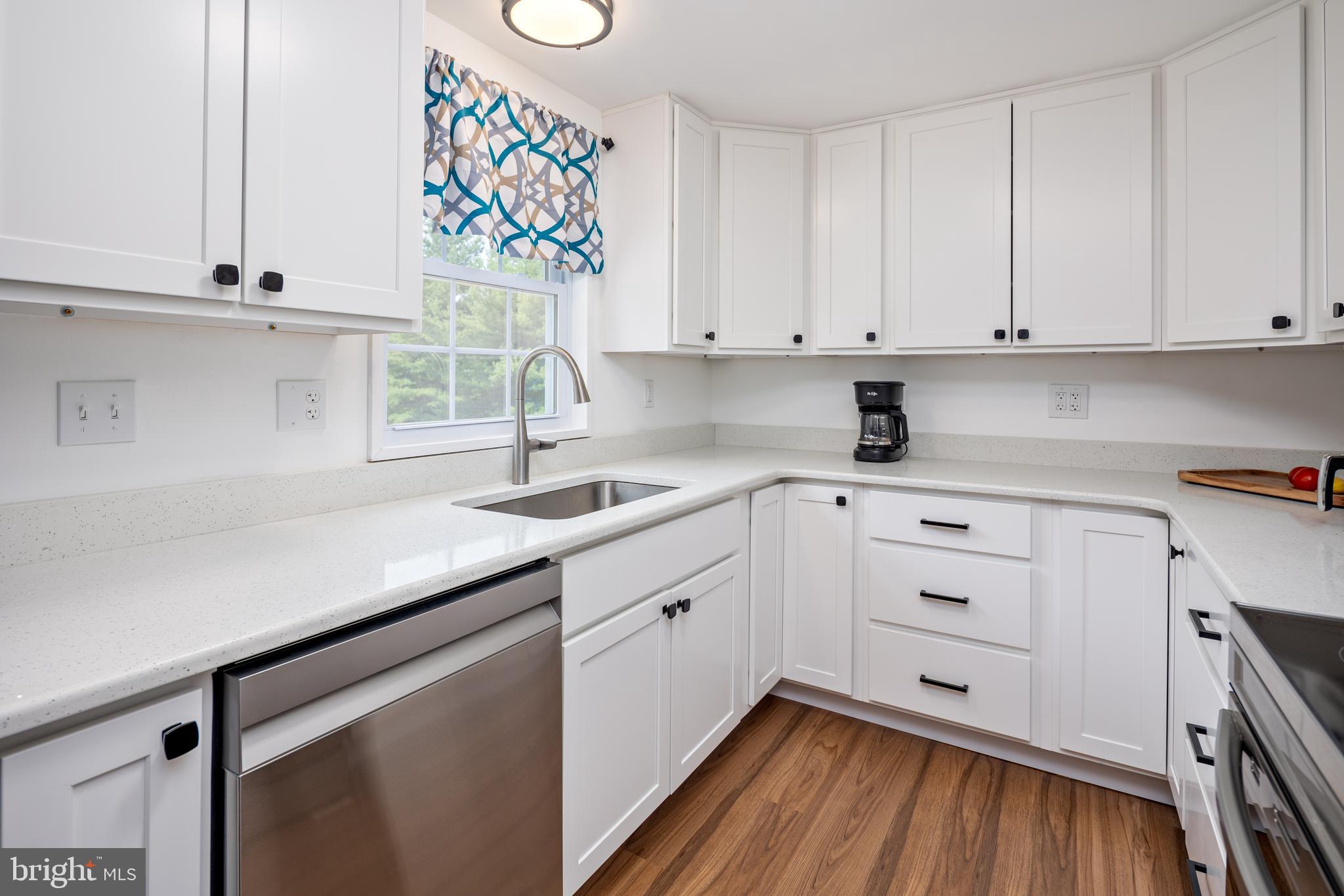 1045 Doyle Road Street, MD 21154 - Photo 10 of 49 a kitchen with granite countertop white cabinets and white appliances with wooden floor