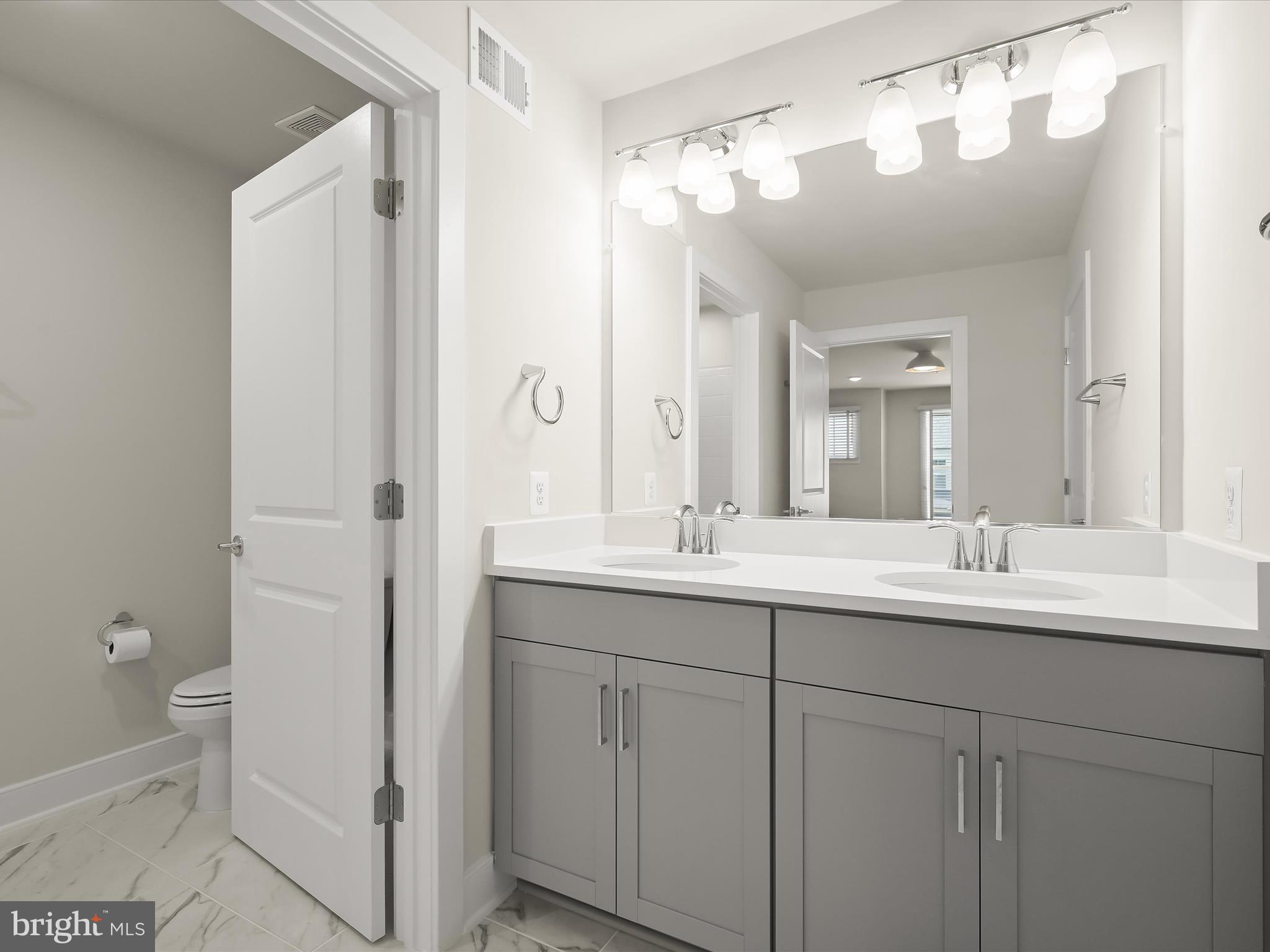 8023 Jennys Way, Unit 9 Fulton, MD 20759 - Photo 38 of 46 a bathroom with a double vanity sink and mirror with toilet