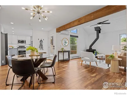a living room with furniture kitchen view and a wooden floor