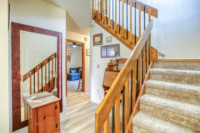 a view of staircase with railing and wooden floor