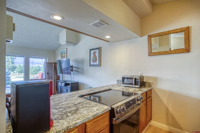 a kitchen with stainless steel appliances granite countertop a sink stove and cabinets