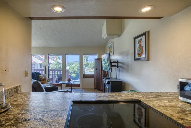 a kitchen with stainless steel appliances granite countertop a sink a stove counter space and living room view