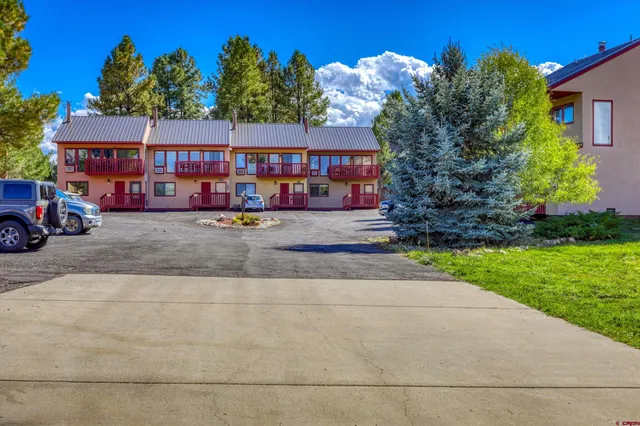 a view of a house with a yard and a fire pit
