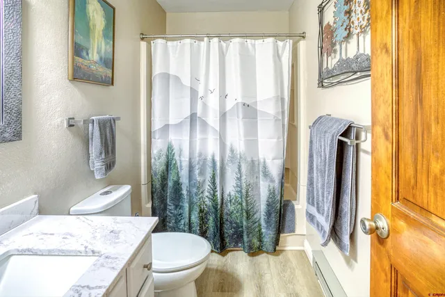 a bathroom with a granite countertop sink toilet and shower