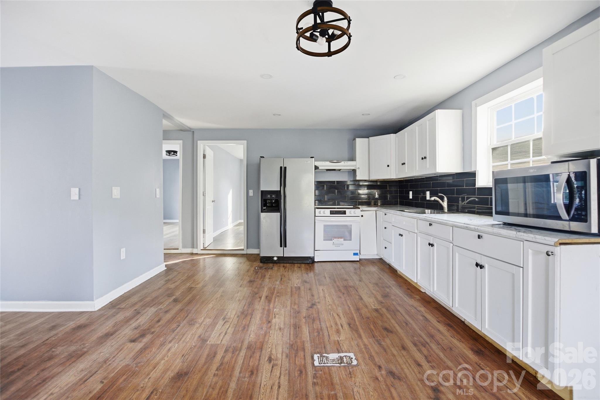 1022 Pine Ridge Road Chester, SC 29706 - Photo 3 of 13 a kitchen with granite countertop a refrigerator oven a sink and dishwasher with wooden floor