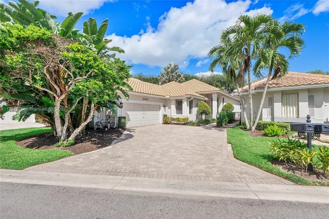 a front view of a house with a yard and potted plants