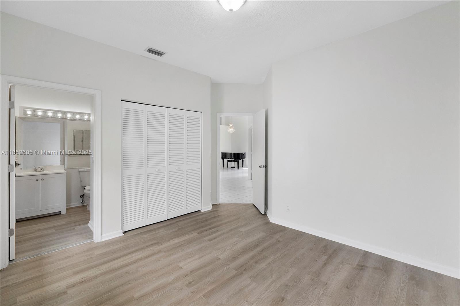 2449 Northwest 64th Street Boca Raton, FL 33496 - Photo 12 of 50 a view of an empty room with wooden floor and a kitchen