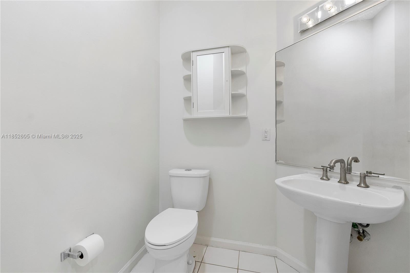 2449 Northwest 64th Street Boca Raton, FL 33496 - Photo 14 of 50 a bathroom with a toilet a sink and mirror