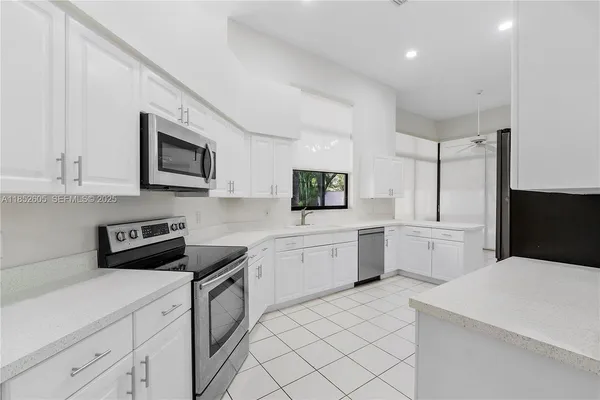 a kitchen with a refrigerator sink and cabinets