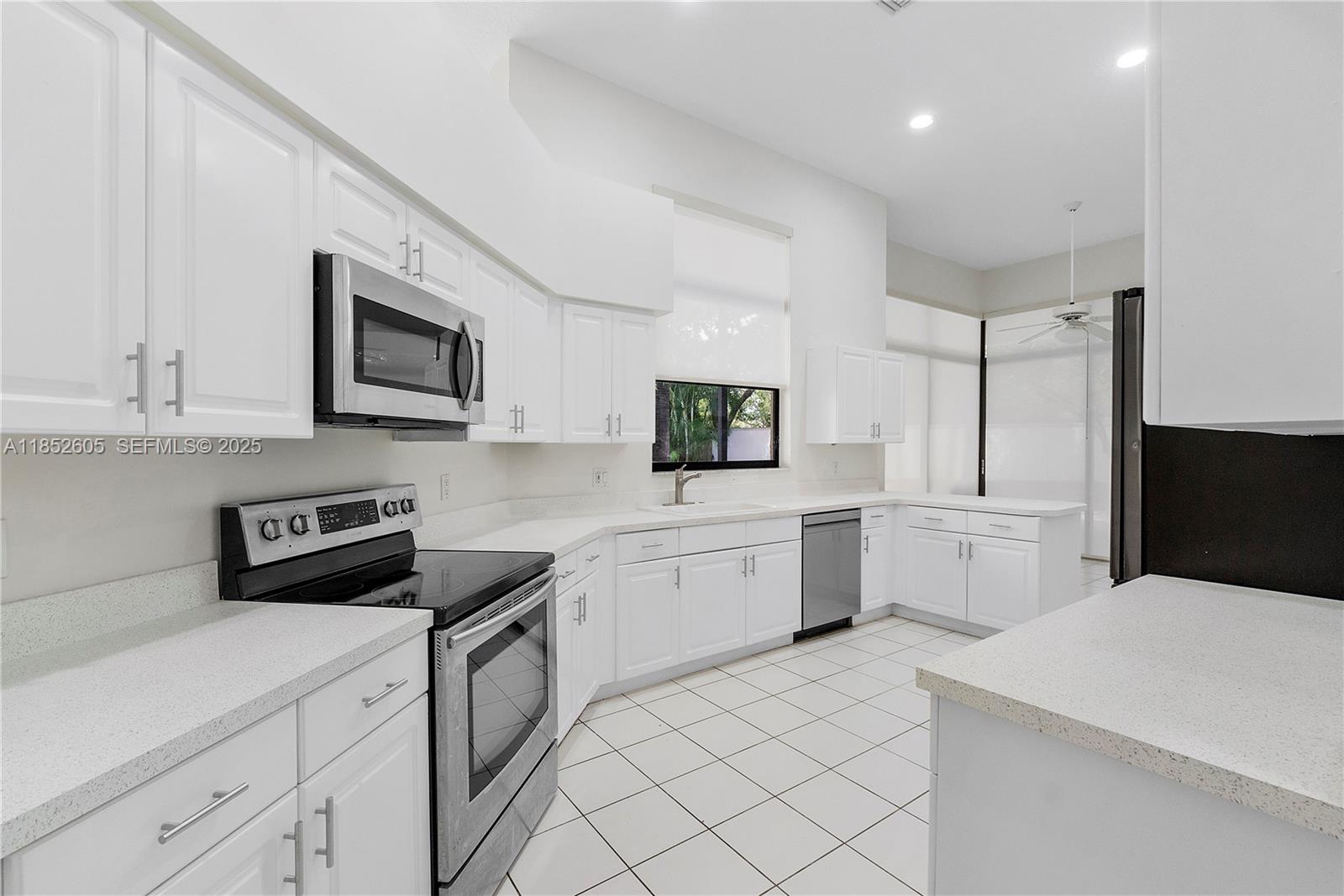 2449 Northwest 64th Street Boca Raton, FL 33496 - Photo 16 of 50 a kitchen with a sink stove and microwave